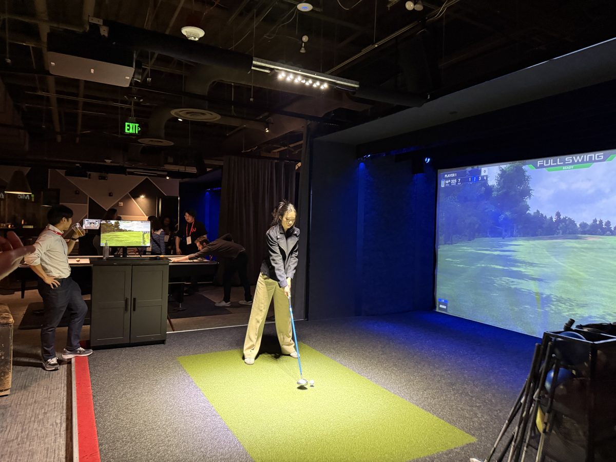 Lab member lining up a shot at an indoor golf simulator