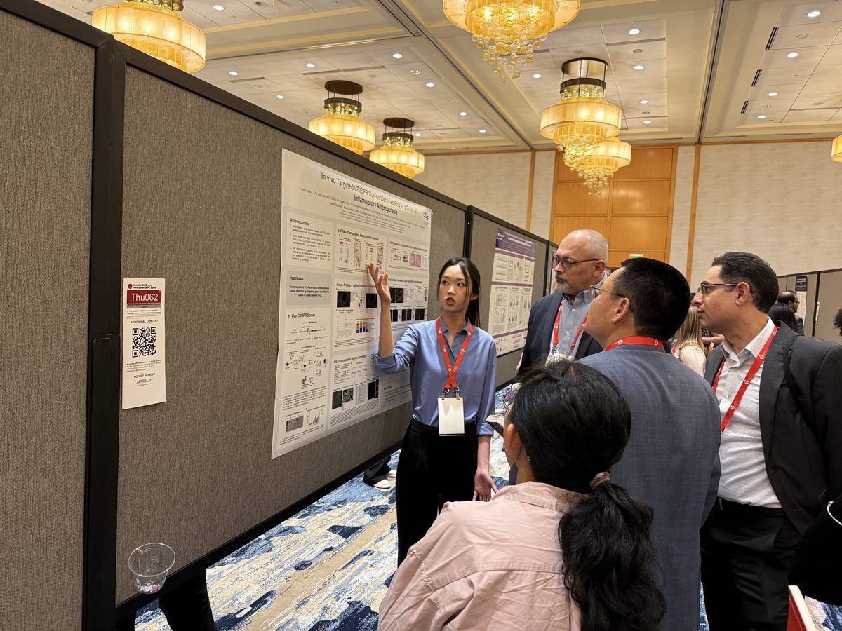 Lab member presenting a poster to a group of attendees