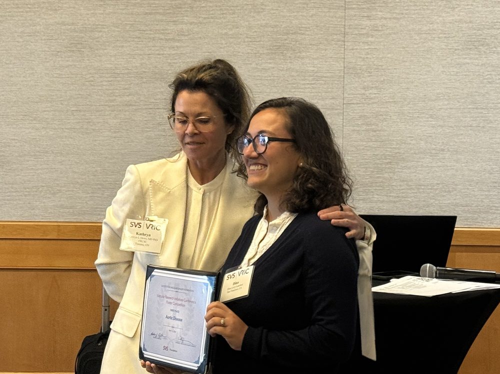 Dina Levy-Lambert holding her poster competition award certificate
